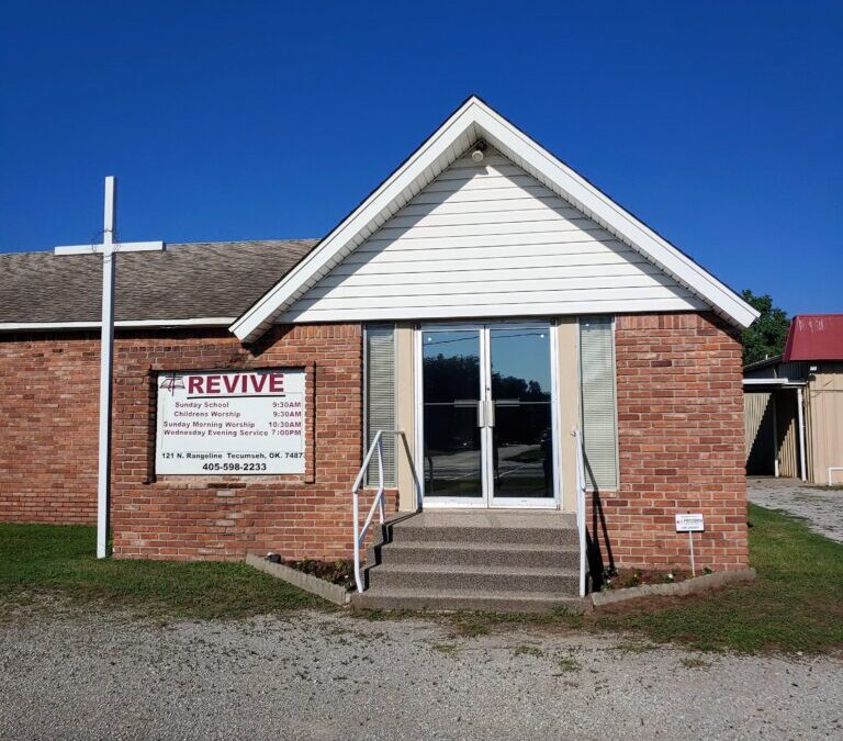 Front doors of Revive Free Will Baptist Church. Church is a brick with glass double door entrance. Stairs lead up to the entrance.