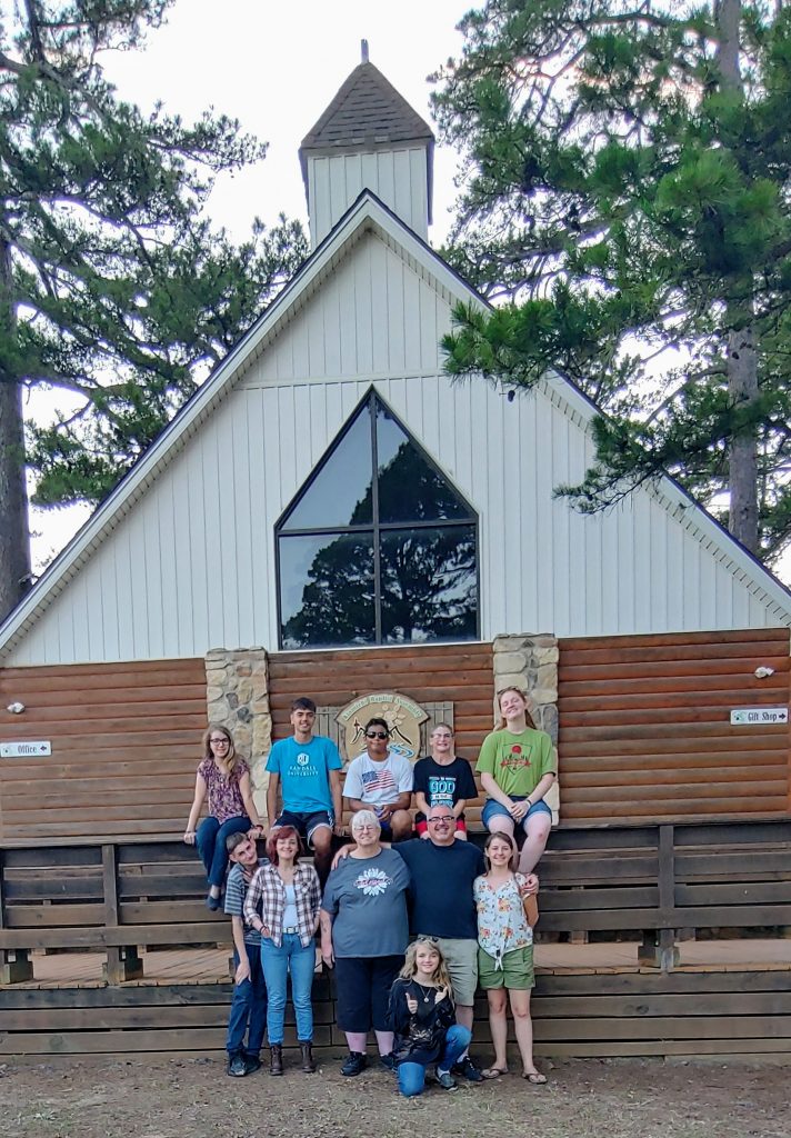 Teen group standing in front of church camp.
